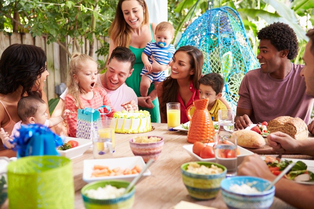 Group Of Families Celebrating Child's Birthday At Home