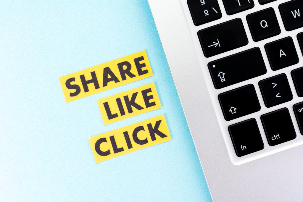 Share, Like Click text beside laptop
