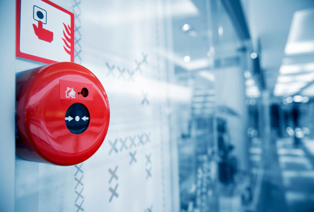 A red fire alarm on the wall of a shopping center